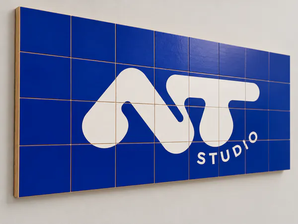 Mural de azulejos azules con el logotipo NT Studio