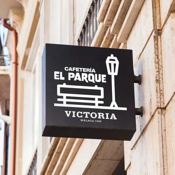 Banderola cuadrada negra de una cafetería en una fachada de piedra