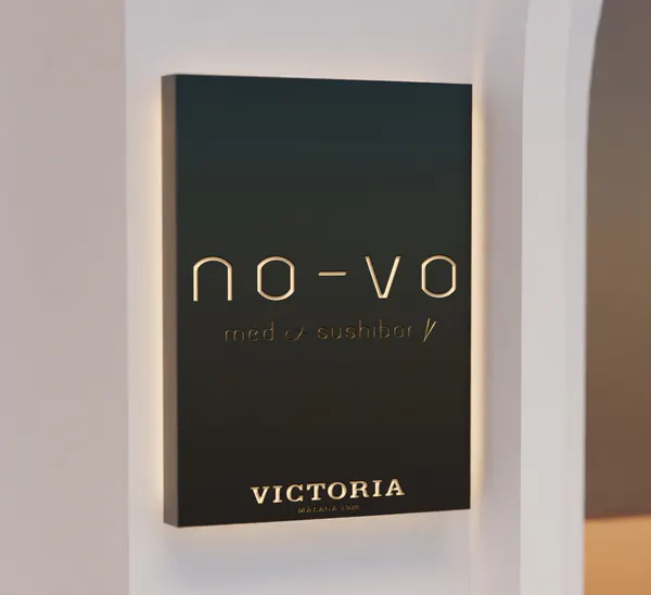 Cajón calado negro con letras retroiluminadas en una pared blanca