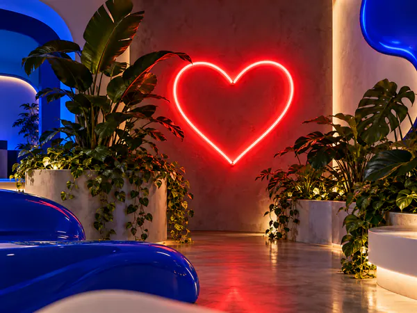 Neón rojo con forma de corazón en un local con plantas